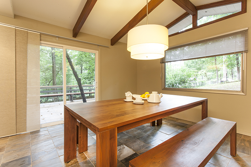 Mid-century modern dining room with vaulted ceiling looking out on spacious deck.